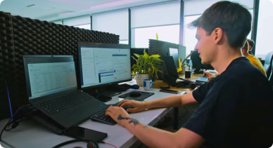 Programista pracujący nad rozwojem systemu POSbistro na kilku monitorach